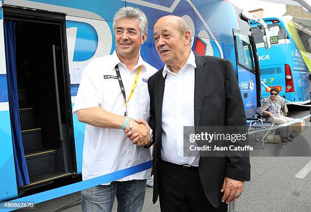 French Minister of Defence Jean-Yves Le Drian greets Marc Madiot, manager of Team FDJ during stage nine of the 2015 Tour de France, a 28 km team time...