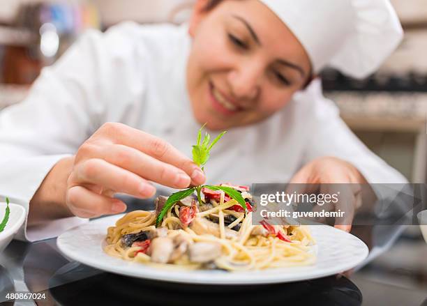 female chef completing pasta - chef finishing stock pictures, royalty-free photos & images