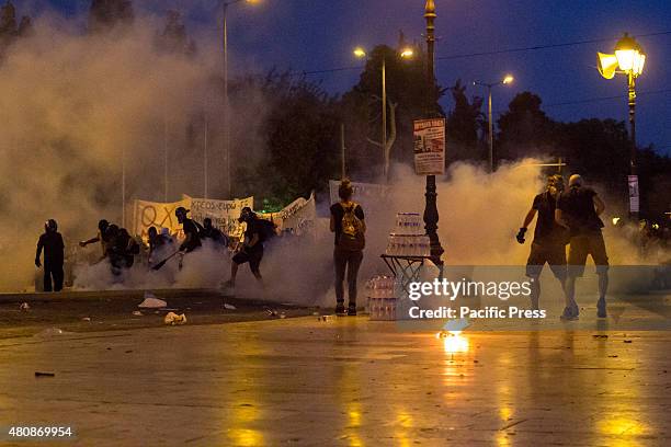 Anti-authoritarians covered with smoke from tear gas bombs thrown by riot policemen. Unions gather in Syntagma square to protest against the voting...