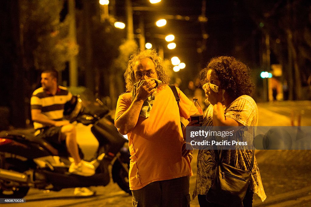 A couple cover their face due to tear gas smoke. Unions...