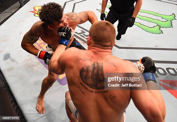 Todd Duffee punches Frank Mir in their heavyweight bout during the UFC event at the Valley View Casino Center on July 15, 2015 in San Diego,...