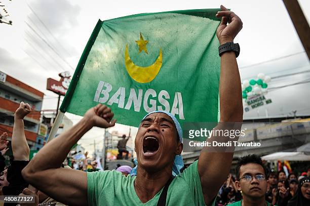 Filipino Muslims cheer outside the presidential palace after the conclusion of the signing of the Comprehensive Agreement on the Bangsamoro between...