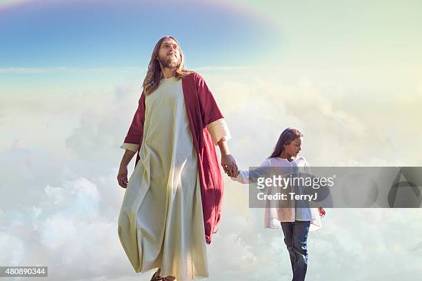 jesus christ camina con un niño entre las nubes - cristo fotografías e imágenes de stock