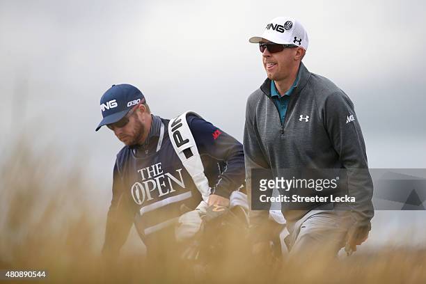 Hunter Mahan of the United States walks with caddie John Wood as he tees off on the 6th hole during the first round of the 144th Open Championship at...