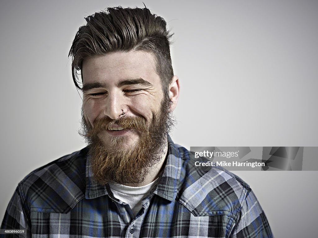 Portrait of bearded man smiling with eyes closed.