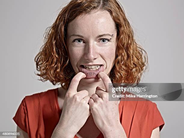 young red-headed woman showing tattooed inside lip - eccentric portrait stock pictures, royalty-free photos & images