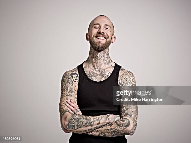 portrait of bearded man with tattoos laughing. - identity stock-fotos und bilder