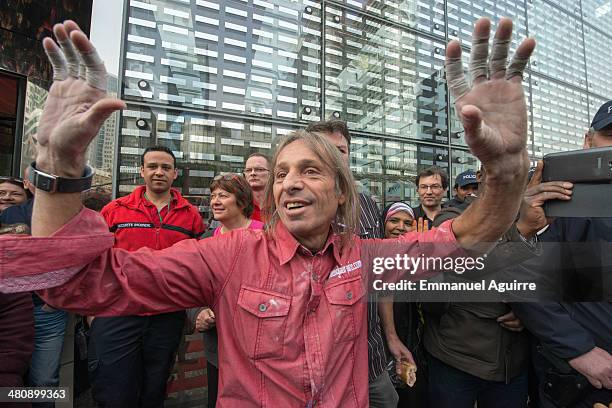 Alain Robert acknowleges media and onlookers after climbing the Ariane Tower, situated in the La Defense business centre on March 27, 2014 in Paris,...