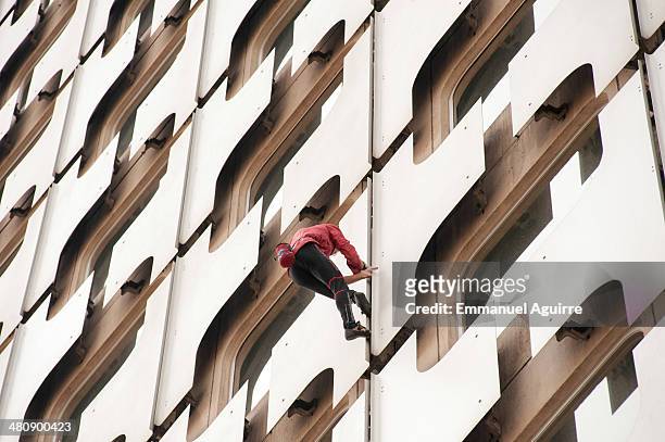 Alain Robert climbs the Ariane Tower, situated in the La Defense business centre on March 27, 2014 in Paris, France. After taking approximately 45...