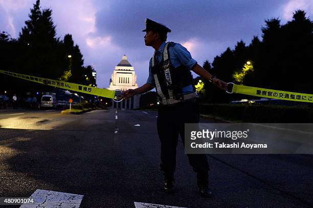 Police Officer holds a police line during a protest outside the National Diet on July 16, 2015 in Tokyo, Japan. The protest is against the security...