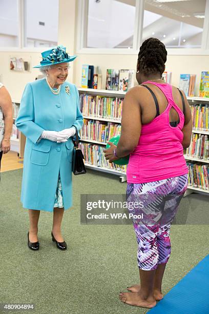 Queen Elizabeth is given a pilates demonstration led by Louise Adams during a visit to Chadwell Heath Community Centre on July 16 in Chadwell Heath,...