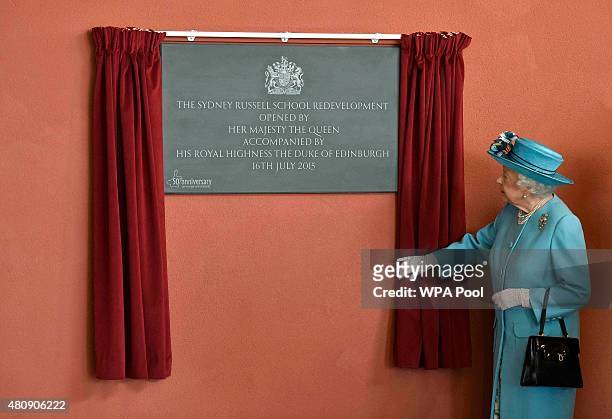 Queen Elizabeth II unveils a plaque during a tour of Sydney Russell School on July 16, 2015 in Dagenham, United Kingdom.