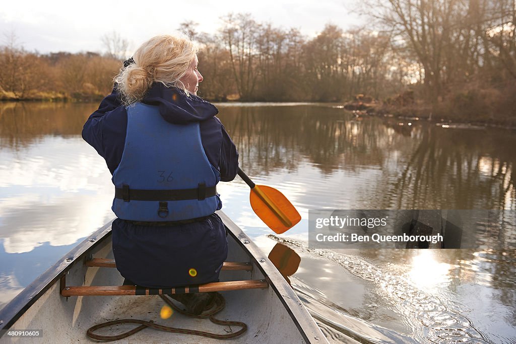 A woman paddling in a canoe on a river