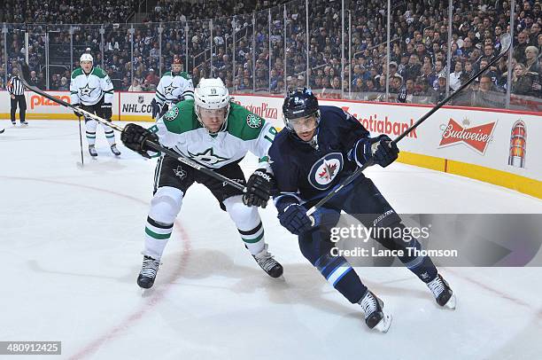 Chris Mueller of the Dallas Stars and Evander Kane of the Winnipeg Jets chase the loose puck towards the boards during first period action at the MTS...