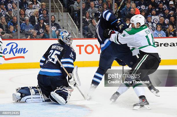 Jamie Benn of the Dallas Stars checks Keaton Ellerby of the Winnipeg Jets in front of goaltender Al Montoya during third period action at the MTS...