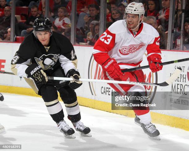 Chris Kunitz of the Pittsburgh Penguins and Brian Lashoff of the Detroit Red Wings turn up ice during an NHL game on March 20, 2014 at Joe Louis...