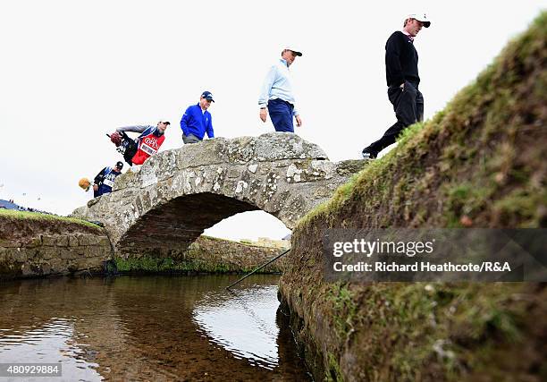 Tom Watson of the United States, Ernie Els of South Africa and Brandt Snedeker of the United States walk over Swilcan Bridge during the first round...
