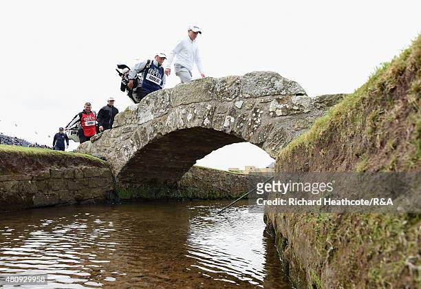 Amateur Paul Kinnear of England walks over the Swilcan Bridge with his caddie Mark Duncalf during the first round of the 144th Open Championship at...