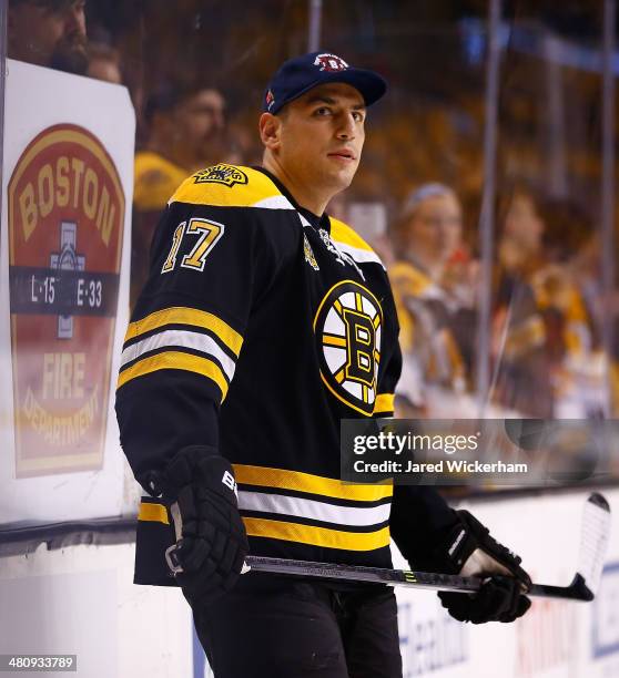 Milan Lucic of the Boston Bruins warms up wearing a Boston Fire Department hat prior to the game against the Chicago Blackhawks at TD Garden on March...