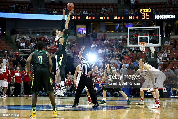 Frank Kaminsky of the Wisconsin Badgers and Isaiah Austin of the Baylor Bears go after the opening jump ball to start the regional semifinal of the...