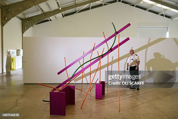 Security guard poses for a photograph alongside a sculpture entitled 'Month of May' by artist Sir Anthony Caro as it stands on display as part of the...