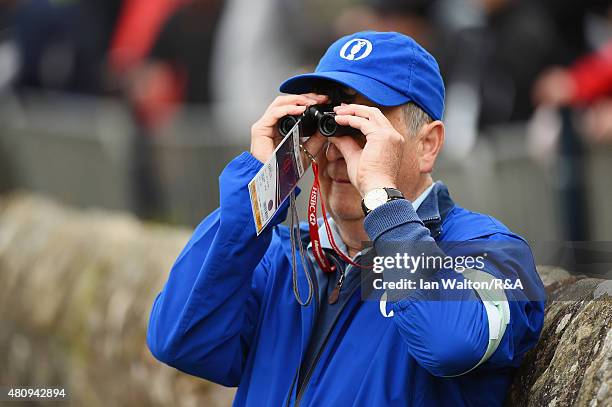 Volunteer uses binoculars during the first round of the 144th Open Championship at The Old Course on July 16, 2015 in St Andrews, Scotland.