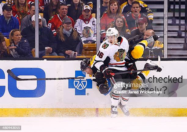 Teuvo Teravainen of the Chicago Blackhawks hits Johnny Boychuk of the Boston Bruins in the first period during the game at TD Garden on March 27,...