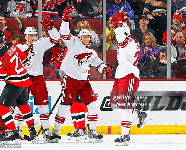 Kyle Chipchura of the Phoenix Coyotes celebrates with his teammates after scoring a first period goal against the New Jersey Devils at the Prudential...