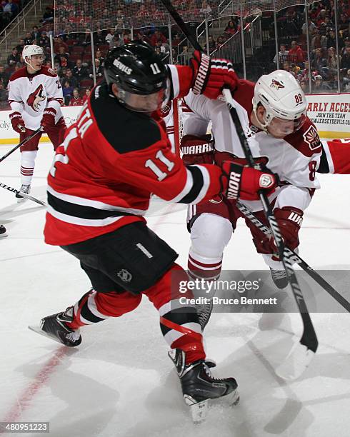 Stephen Gionta of the New Jersey Devils gets the stick up on Mikkel Boedker of the Phoenix Coyotes during the second period at the Prudential Center...