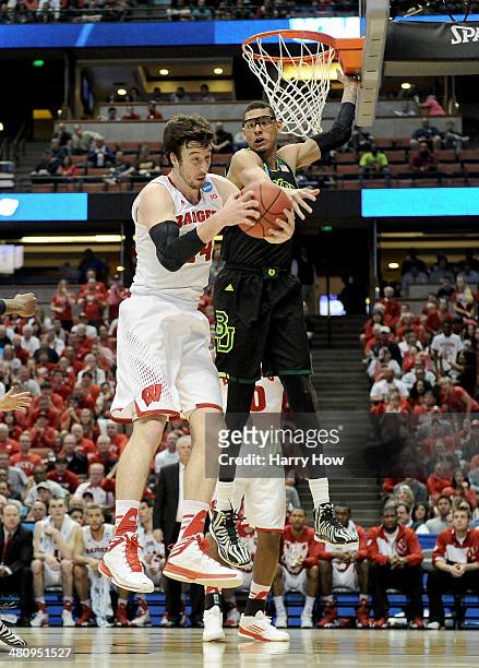 Frank Kaminsky of the Wisconsin Badgers grabs a rebound against Isaiah Austin of the Baylor Bears in the first half during the regional semifinal of...