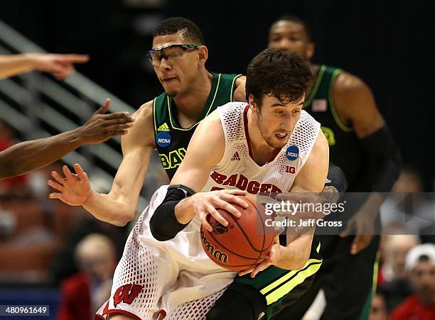 Frank Kaminsky of the Wisconsin Badgers is fouled in the second half by Isaiah Austin of the Baylor Bears during the regional semifinal of the 2014...