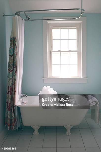 bathroom with clawfoot tub filled with bubbles. - 据え置き型バスタブ ストックフォトと画像