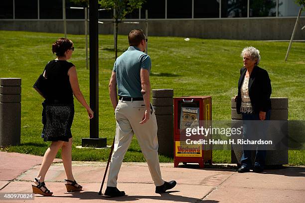 Aurora theatre shooting victim Joshua Nowlan, middle with cane, walks towards Marlene Knobbe, grandmother of shooting victim Micayla Medek, as they...