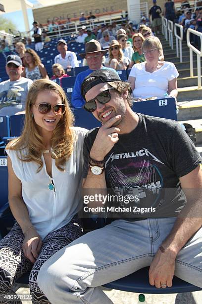 Free agent pitcher and former Oakland Athletics Barry Zito sits in the stands with his wife Amber prior to the spring training game between the...