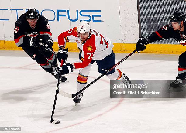 Brandon Pirri of the Florida Panthers crosses sticks with Andrei Loktionov and Eric Staal of the Carolina Hurricanes at the BB&T Center on March 27,...