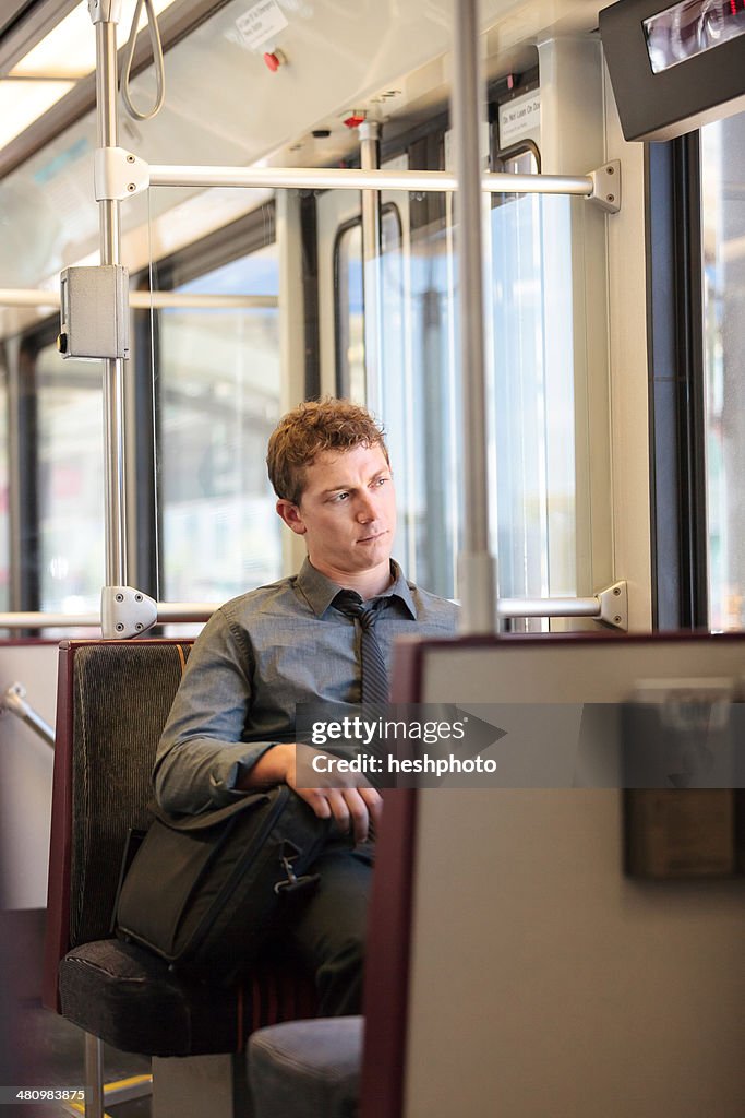 Mid adult office worker looking bored on train journey
