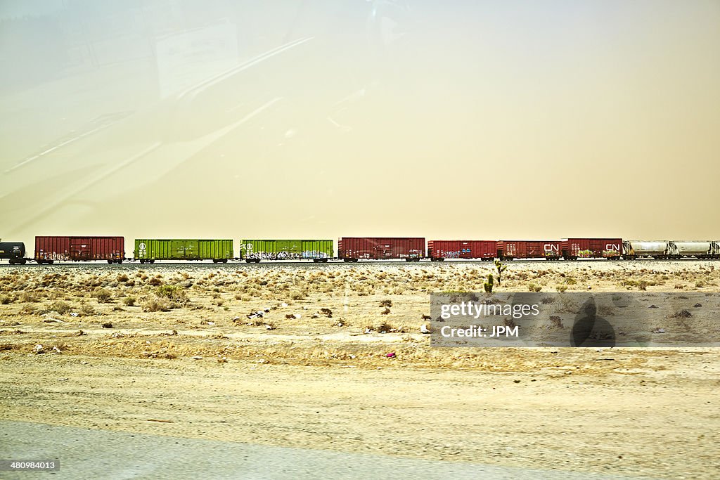 Freight locomotive moving through arid landscape, California, USA