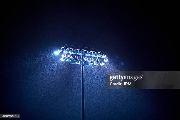 dark sky and floodlight in rain - lumière de stade ou de chantier photos et images de collection