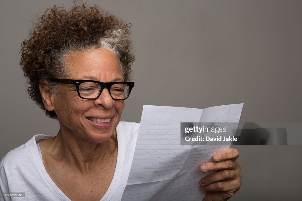 Studio portrait of happy senior woman reading a letter