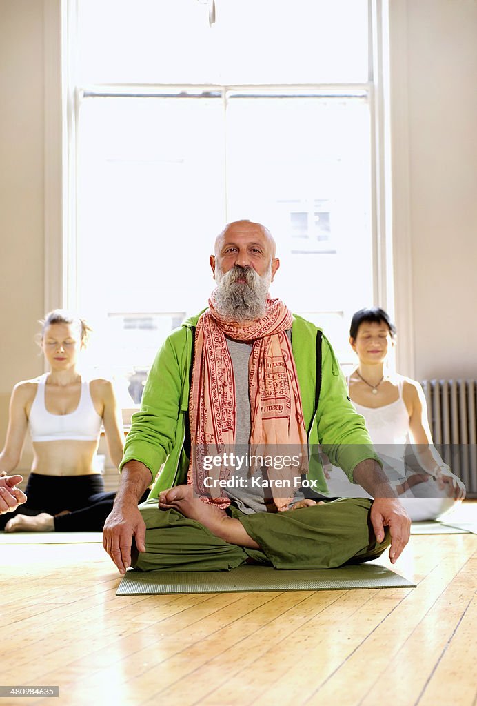 Mature man in lotus pose in yoga class