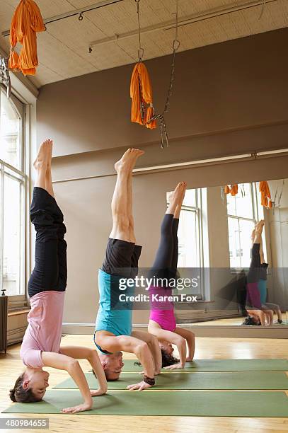 people doing headstands (salamba-shirshasana) in yoga class - shirshasana stock pictures, royalty-free photos & images