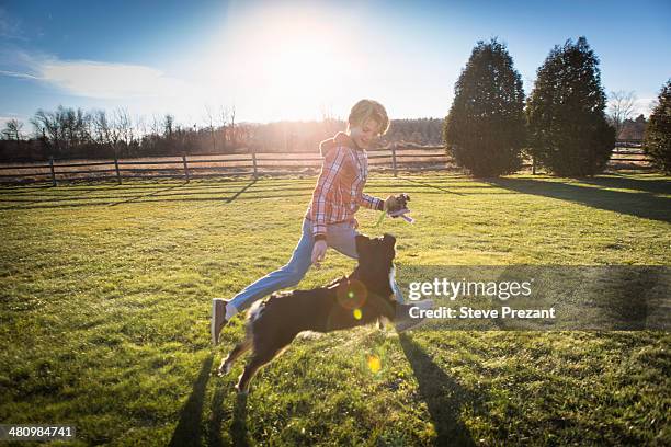 boy running with dog - boy running with dog stock-fotos und bilder