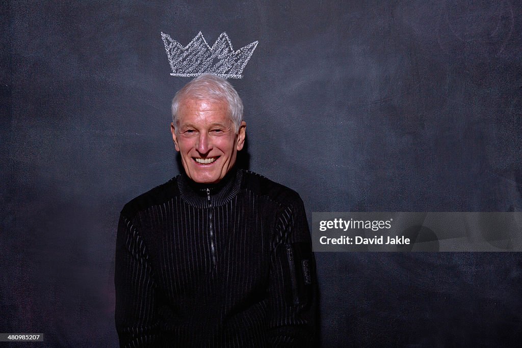 Portrait of senior man in front of chalked crown on blackboard