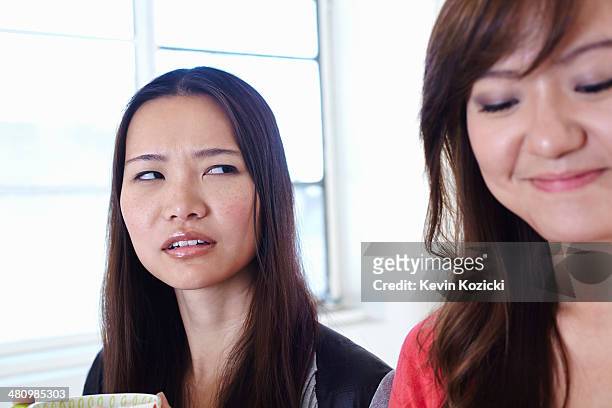 two young women in kitchen in disagreement - envy stock pictures, royalty-free photos & images