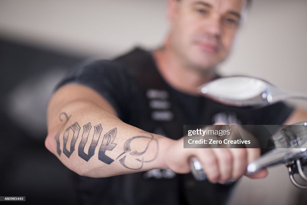 Close up of mature man sitting on motorcycle indoors