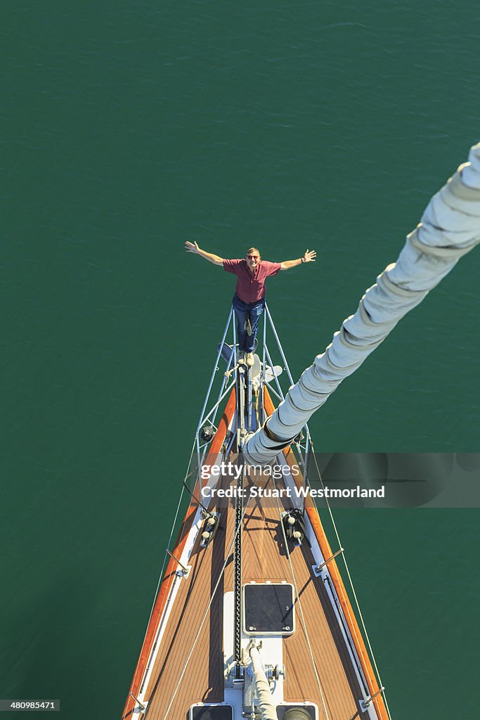 Senior man seen sailing from above with arms outstretched, San Diego, California, USA