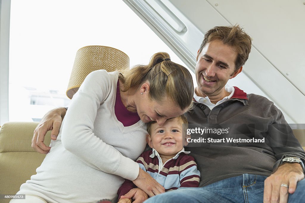 Mid adult couple and toddler son sitting on couch