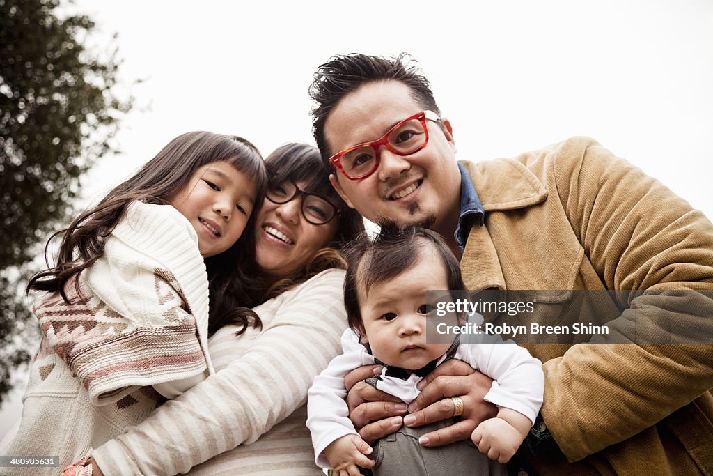 Family portrait of mid adult couple with daughter and baby boy in park