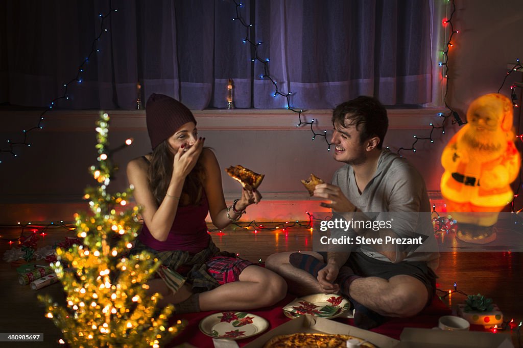 Young couple enjoying pizza at christmas