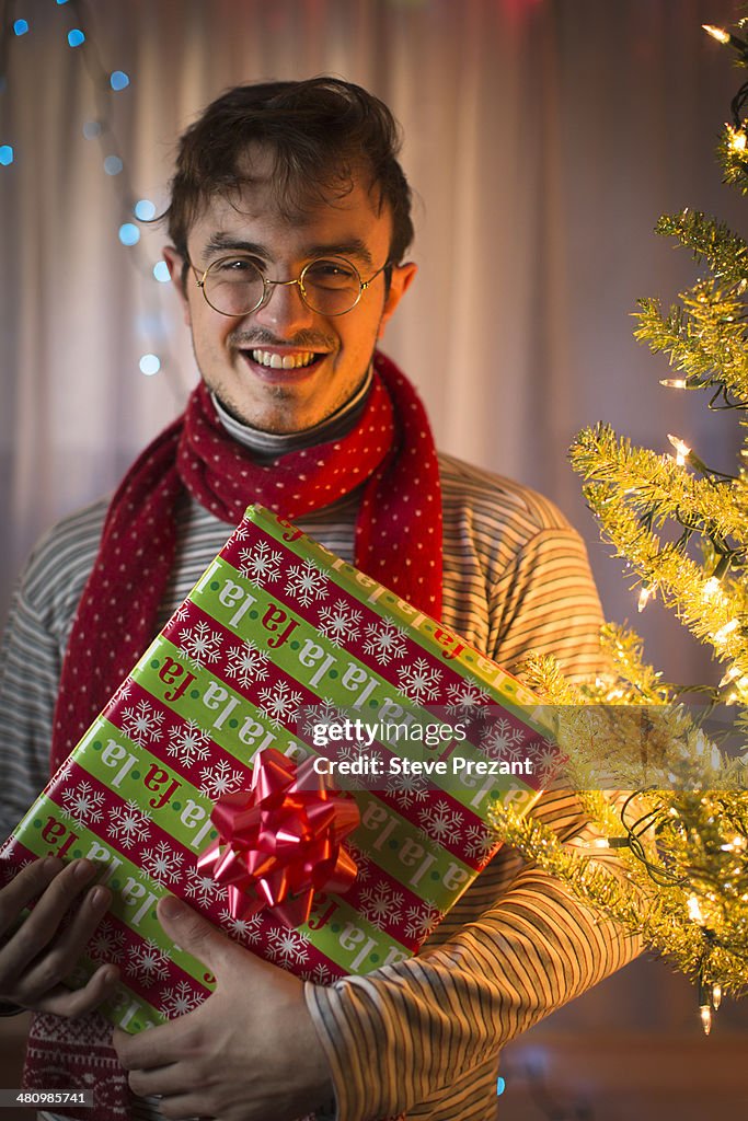 Portrait of young man holding christmas gift